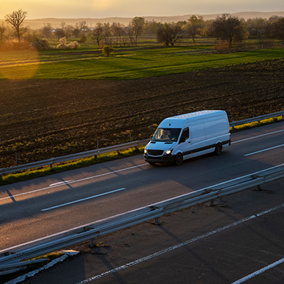 White Van Driving Along Motorway In Sunset