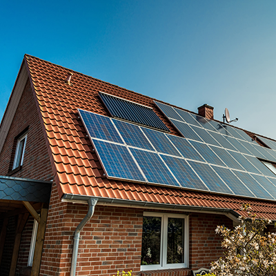 Red Brick House With Solar Panels On Roof