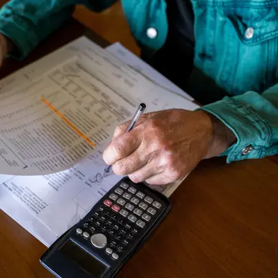 Anonymous Senior Man Doing Paperwork At Home Office