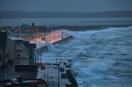 Giant waves and violent storm jumping over the pier in the seaside town of Tramore, Waterford, Ireland